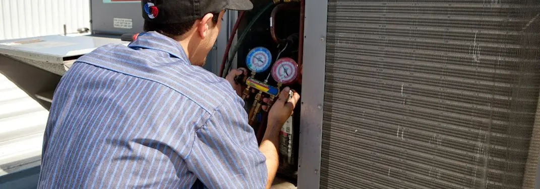 HVAC technician servicing a condenser unit in Wailua Homesteads