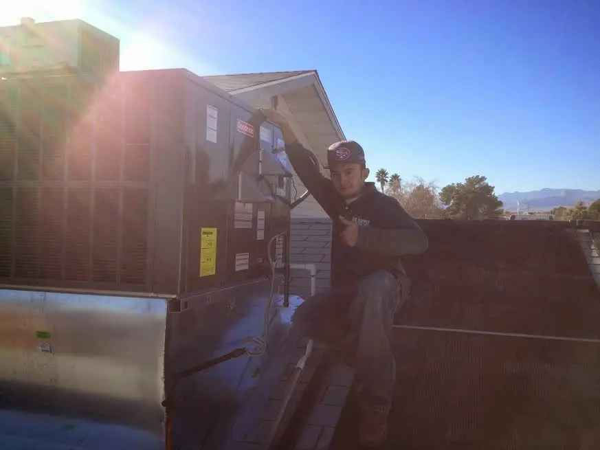 HVAC technician performing AC Tune-Up on a rooftop unit in Wailua Homesteads
